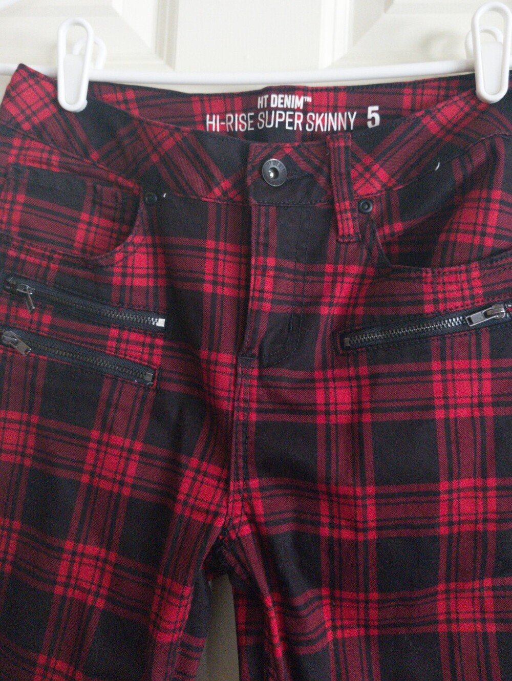 Red and black plaid skinny jeans with zipper pockets